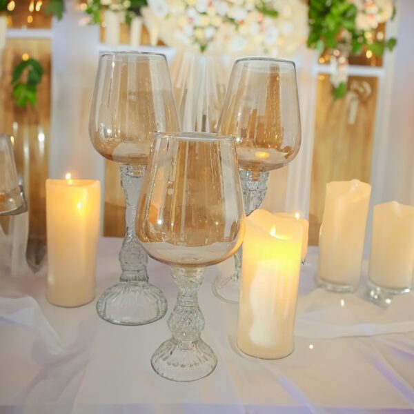 Glass candle holder casting a warm glow in the room with a lit candle, enhancing room decoration in a sleek glass shape